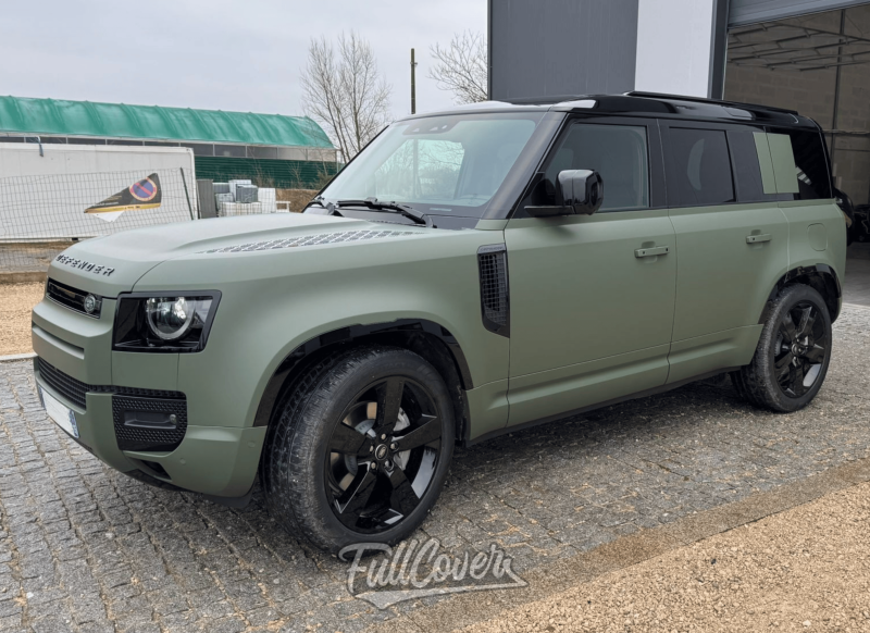 Un covering total vert militaire pour ce Land Rover Defender 110, prêt à dominer les routes d’Orléans